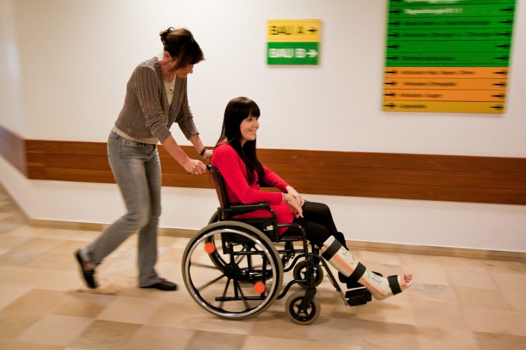 Kvinde i kørestol med brækket ben