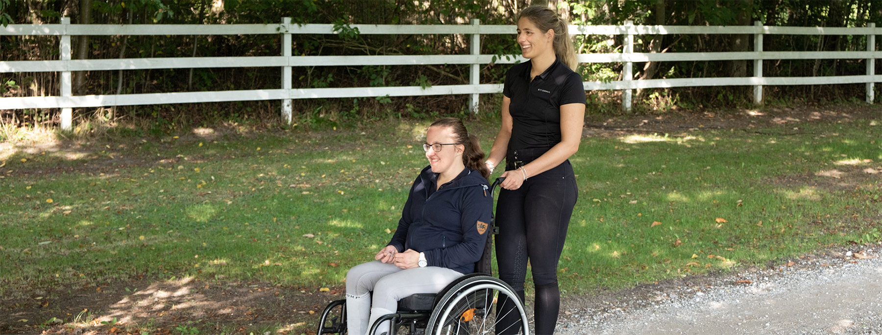 handicaphjælper og pige i kørestol